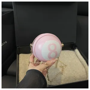 Close-up of pink pool ball crossbody bag with golden chain and number 8 detail