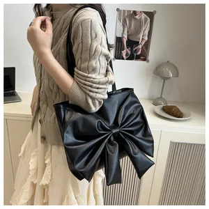 Dettaglio della borsa tote nera con grande fiocco decorativo e finitura in pelle PU
