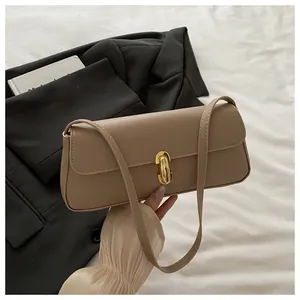 Detail of khaki pebbled leather bag featuring a gold twist lock and a slim shoulder strap