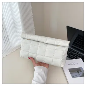 Detailed close-up of a white quilted nylon clutch bag with a gold ring clasp accent