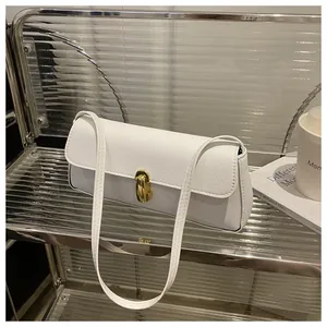 Close-up of white leather handbag with golden oval metal swivel lock on glass shelf