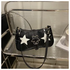 Detail of black pebbled leather bag with white star patches and contrast stitching
