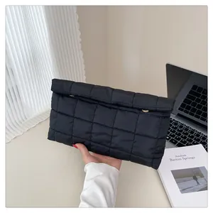 Close-up of black quilted nylon envelope bag showing its glossy finish and sleek texture