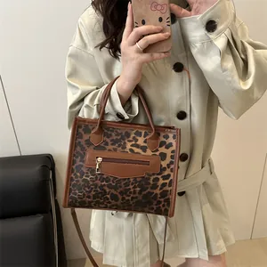 Leopard print crossbody handbag with brown leather trim and golden zipper detail