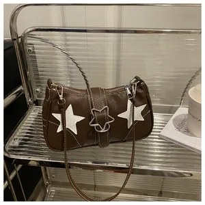 Detail of vintage brown shoulder bag featuring white star patchwork and silver metal buckle