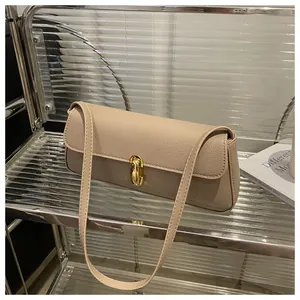 Close-up of khaki pebbled leather bag featuring a polished gold oval metal lock closure