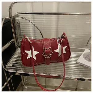 Close-up of red pebbled leather shoulder bag with white star patches and star metal buckle