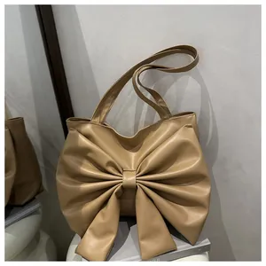 Dettaglio della borsa tote beige con un grande fiocco decorativo in pelle 3D