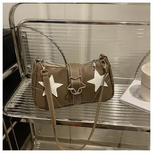 Close-up of star-shaped metallic buckle and star patchwork on brown leather bag