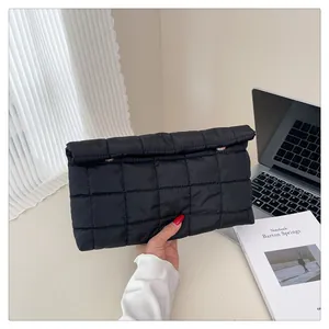 Close-up of black quilted envelope clutch bag with gold hardware and elegant stitching