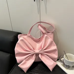 Elegante borsa tote rosa con grande fiocco esposta in un accogliente caffè per donna