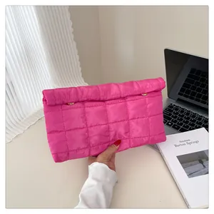 Detail of hot pink quilted envelope clutch with stylish gold metal buckle and pleated fabric