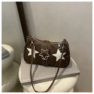 Detail of a brown lychee pattern bag with white star patches and silver hardware