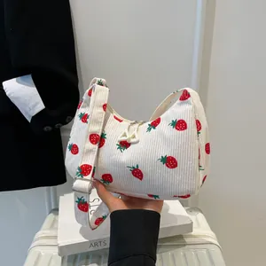 White corduroy dumpling bag with red strawberry print and adjustable wide strap