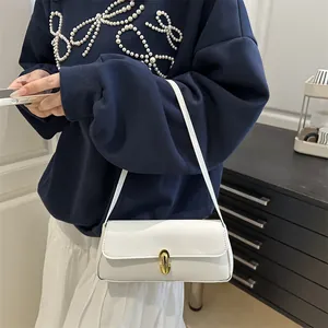 White textured leather underarm bag featuring a gold U-shaped metal lock and slim strap