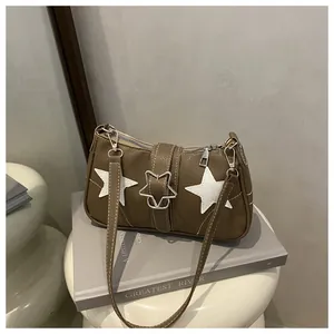 Detail of dark brown star-patterned bag with metallic buckle and white stitching