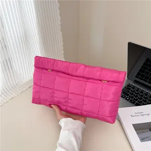 Rose pink quilted envelope clutch bag with gold fastener for a modern minimalist look