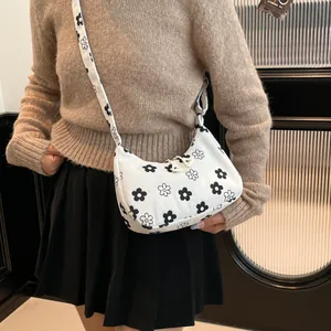 Floral print corduroy crossbody bag with adjustable strap worn by model in casual style