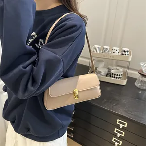 Elegant beige pebbled leather shoulder bag with gold twist lock shown on a model