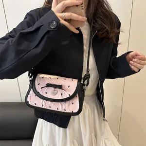 Chic pink textured crossbody bag with black bow and silver heart charm for women