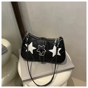 Detailed shot of a black pebbled leather handbag featuring white star patterns and star clasp