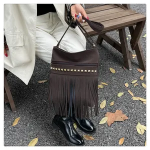 Vue détaillée du sac en cuir PU marron foncé avec clous dorés et longues franges de style