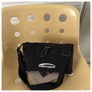 Détail du sac bandoulière noir FANYISSA avec texture nylon et détail de fermeture tissé