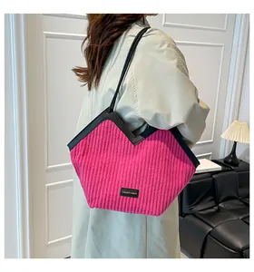 Detail of pink corduroy tote bag with V-shaped opening and black leather strap