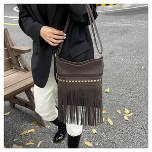Sac bandoulière bohème marron foncé avec clous dorés et détails de franges