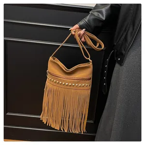 Détail d'un sac bandoulière marron en PU avec de longues franges et des clous dorés
