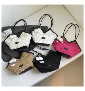Close-up of five corduroy shoulder bags in beige, white, pink, tan, and black variants