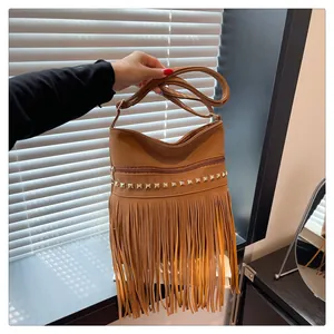 Détail d'un sac bandoulière bohème marron avec de longues franges et clous dorés