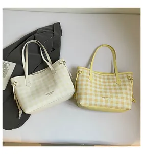 Detailed view of checkered tote bags with side drawstring accents and branding