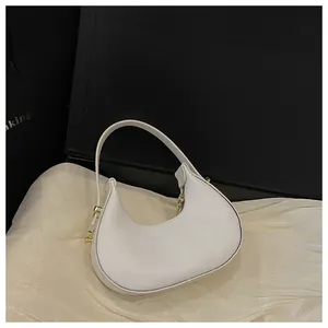 Detail view of a white crescent Hobo bag with smooth PU leather and gold hardware
