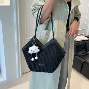Black corduroy tote bag with V-shaped design and plush cloud charm accessory