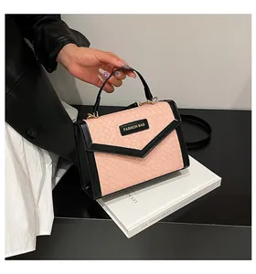 Detail of pink woven texture and black leather trim on a modern crossbody fashion bag