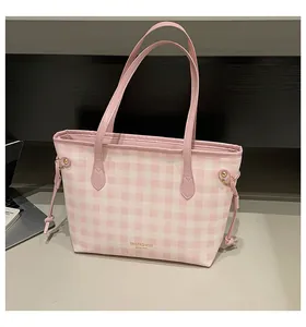 Detailed close-up of pink and white checkered tote bag with gold logo and side drawstring