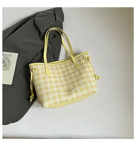 Detail of yellow checkered tote bag with drawstring sides and slim shoulder straps