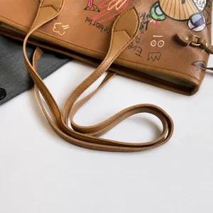 Detailed shot of comfortable brown tote bag handles with colorful bear graffiti print