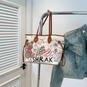 White graffiti tote bag with bear print and brown leather handles in street style