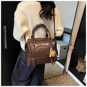 Bruine vintage Boston tas met decoratieve stiksels en een unieke dobbelsteen bedel