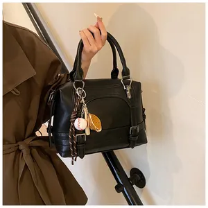 Detailopname van zwarte lederen Boston tas met honkbal hanger gedragen door een vrouw