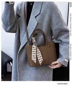 Sac seau en cuir marron avec détail écharpe pied-de-poule sur un mannequin en manteau