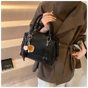 Detail van zwarte Boston-tas van oliewasleer met uniek honkbalhandschoen-accessoire