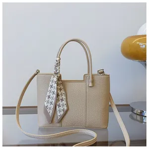 Vue détaillée du sac seau kaki avec texture grainée et foulard en soie à motif pied-de-poule