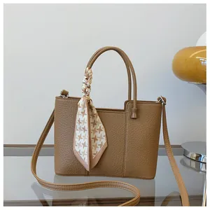 Détail du sac cabas marron vintage avec texture litchi et foulard en soie sur la poignée