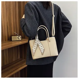 Sac fourre-tout beige avec texture litchi et foulard en soie décoratif sur mannequin