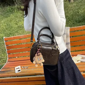 Retro dark brown crossbody bag with Lucky Clover embossing and a cute bear charm