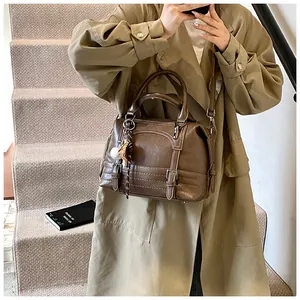Detail van vintage olie-was lederen Boston tas met retro bedeltjes op een bruine tas