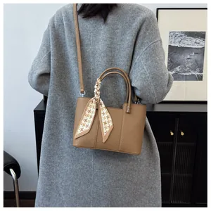 Sac seau en cuir marron avec détail de foulard en soie pied-de-poule sur mannequin